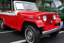 Front view shows narrow white walls and original wheel covers on a 1969 Jeepster Commando