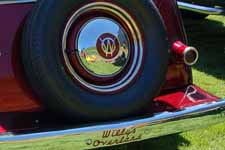 Sharp spare tire and chrome hubcap mounted behind re-plated 1950 Willys Overland Jeepster rear bumper