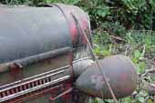 Nice radiater shell, hood sections and headlights on old Dodge truck in vintage car junkyard