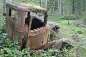 Original cab and front end from vintage Ford pickup in old car wrecking yard