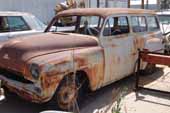 Very straight 2 door station wagon stored in vintage car junk yard