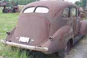 Nice 1940's 4-door sedan vintage project car in storage at old car junk yard