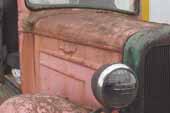 Original hood panels and headlamps on 1936 Chevy truck in vintage car wreckingyard