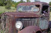 Rusty but original vintage Dodge truck, stored outside in grass field
